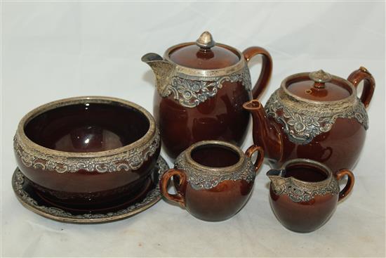 Wedgwood treacle glazed pottery silver mounted part tea set, c.1906, the hot water pot 13cm., one plate broken (13)(-)